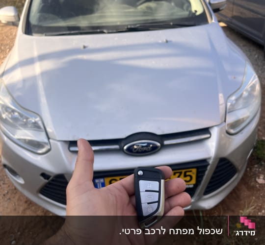 מפתח רכב מול מכונית חונה בשטח פתוח
